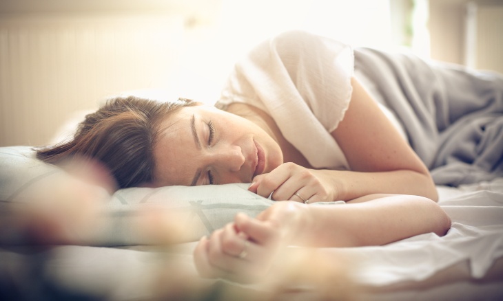 A woman sleeps in her bed.