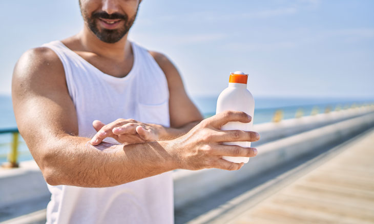 Man protecting his skin by applying sunscreen