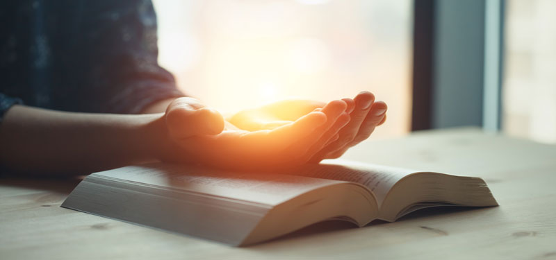 Person placing hand on bible