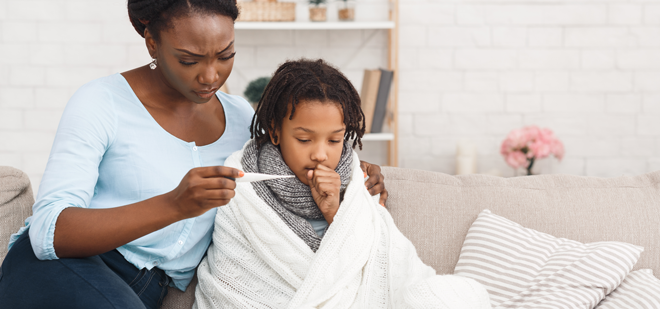 Mother checking the temperature of her sick child.